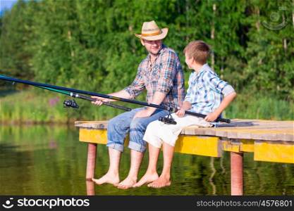 boy and his father fishing togethe. boy and his father fishing together from a pier