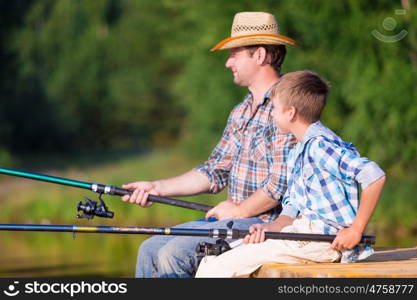 boy and his father fishing togethe. boy and his father fishing together from a pier