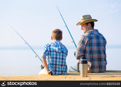 boy and his father fishing togethe. boy and his father fishing together from a pier