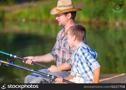 boy and his father fishing togethe. boy and his father fishing together from a pier