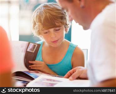 Boy and his father in library with books. Boy and his father in library