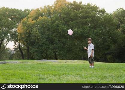 Boy at birthday party holding balloon