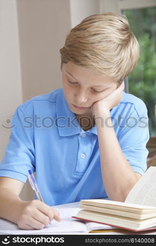 Boy At Home Finding Homework Difficult