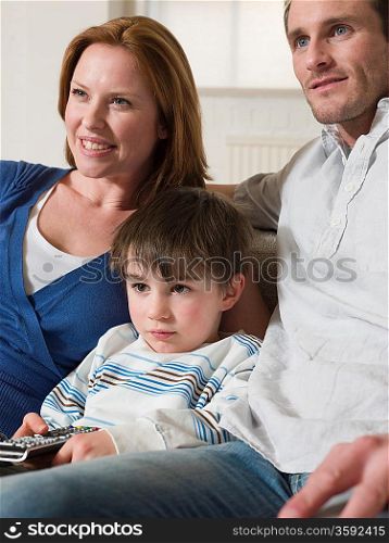 Boy Between Parents Watching Television