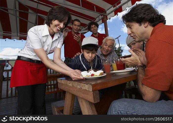 Boy celebrating his birthday with his family in a restaurant