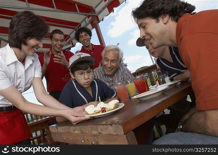 Boy celebrating his birthday with his family in a restaurant