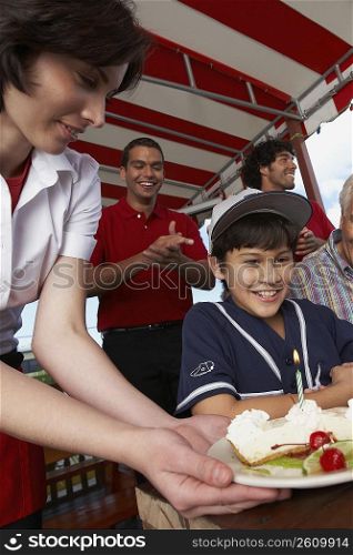 Boy celebrating his birthday with his grandfather in a restaurant