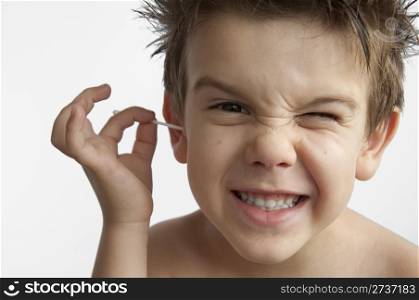 Boy cleans his ear. Isolated white background
