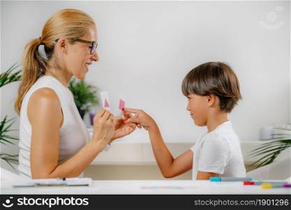 Boy doing a school assessment test. Psychologist holding shapes, and boy recognizing them.. Boy doing a school assessment test