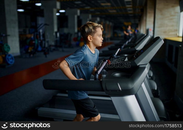 Boy doing exercise on treadmill in gym, running machine. Schoolboy on training in sport club, health care and healthy lifestyle. Boy doing exercise on treadmill, running machine