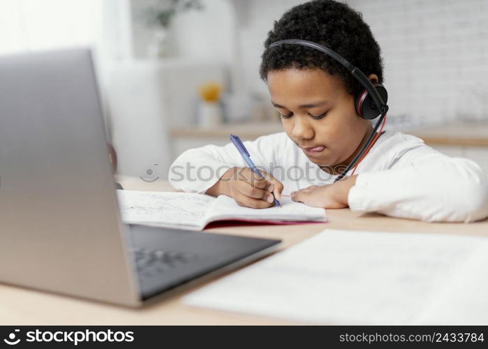 boy doing homework with use laptop