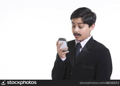 Boy dressed as businessman looking at sms on mobile phone