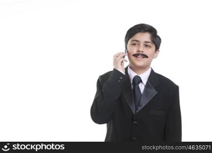 Boy dressed as businessman talking on mobile phone