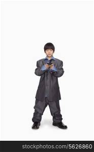 Boy dressed up as businessman checking cell phone