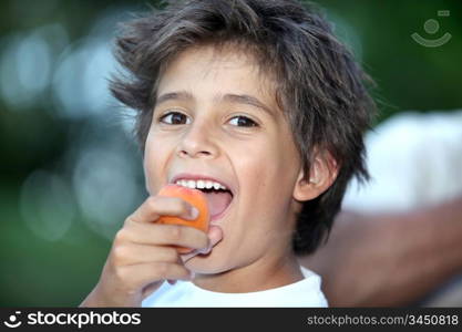 Boy eating an apricot