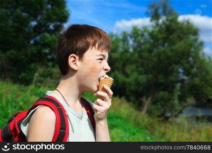boy eats ice cream in the summer day