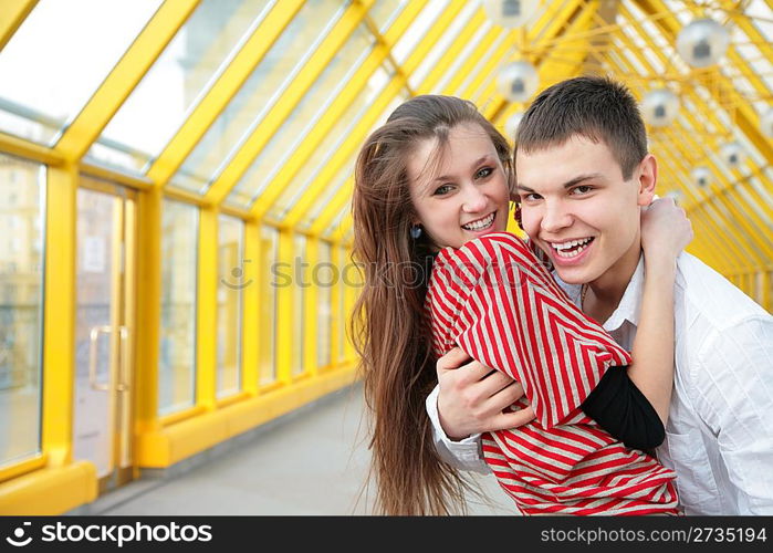 boy embraces girl on footbridge