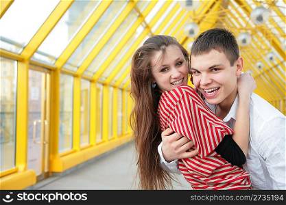 boy embraces girl on footbridge