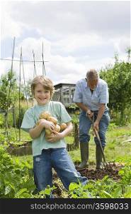 Boy gardening with grandfather
