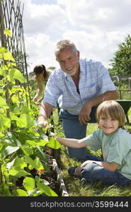 Boy gardening with grandfather, portrait