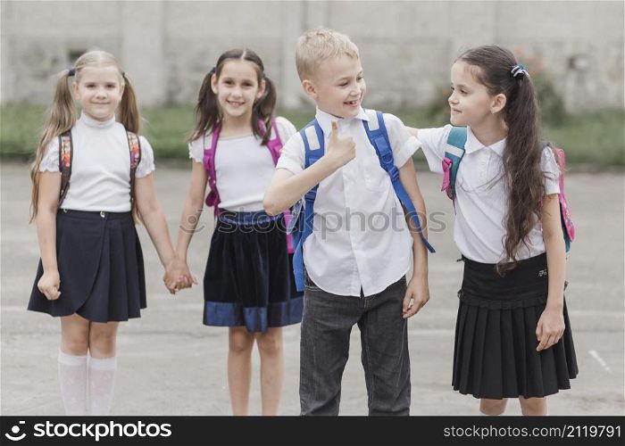 boy gesturing thumb up while standing near girl