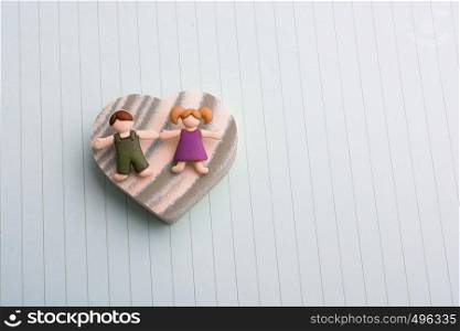 Boy girl figurine on a Heart shape as love conception