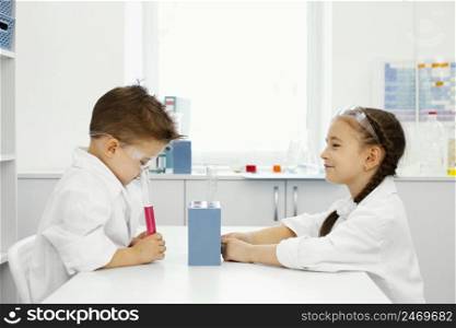 boy girl scientists laboratory with safety glasses