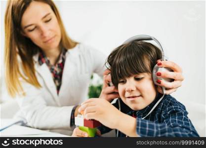 Boy Having a Hearing Exam in the Audiologist’s Office. Pediatric Audiologist Testing Hearing with a Little Boy