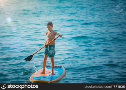 Boy having fun with Stand Up Paddling Board. Stand Up Paddling Board