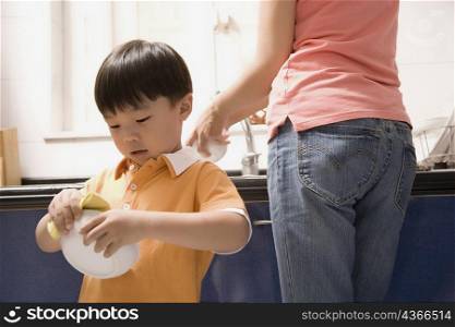 Boy helping his mother in the kitchen