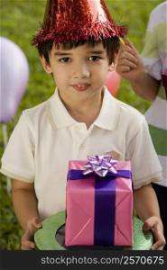 Boy holding a birthday present and smiling