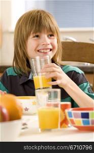 Boy holding a glass of orange juice and smiling