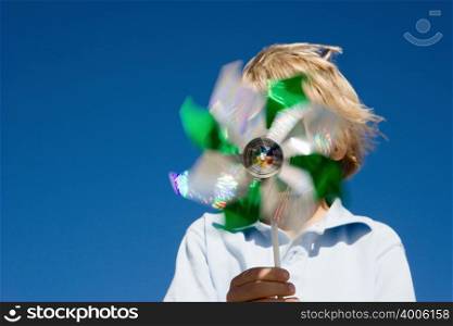 Boy holding pinwheel in front of face