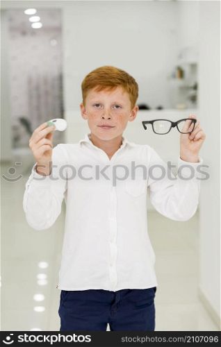 boy holding plastic container contact lenses eyeglasses looking camera