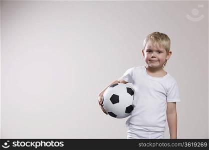 Boy holding soccer ball, portrait