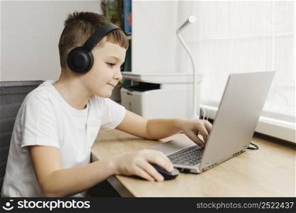 boy home using laptop headphones