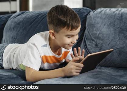 boy home waving someone digital tablet