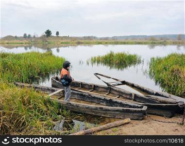 Boy in a boat on the river bank.