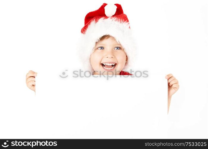 Boy in a cap of santa holds the blank sheet