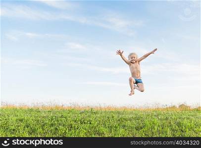 Boy in field jumping in mid air