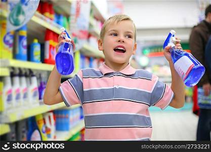 Boy in household chemical goods department in shop