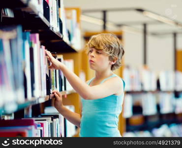 Boy in library choosing books. Boy in library