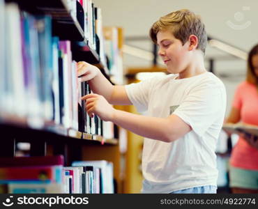 Boy in library choosing books. Boy in library