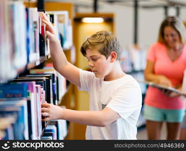 Boy in library choosing books. Boy in library