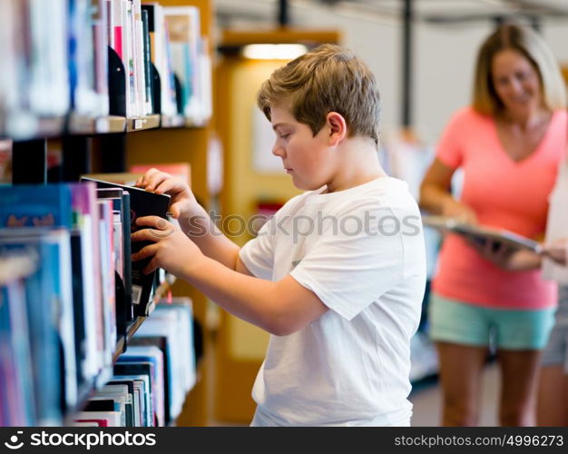 Boy in library choosing books. Boy in library