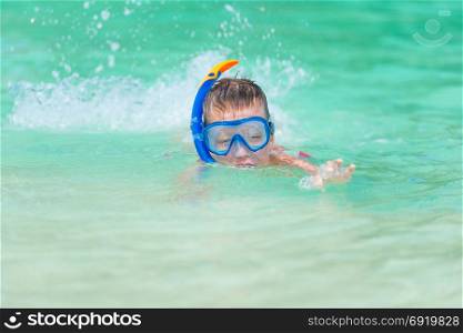 boy in the sea water in the steamy poppy with snorkel tube