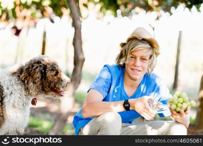 Boy in vineyard. Boy picking grapes in vineyard with a dog