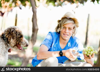 Boy in vineyard. Boy picking grapes in vineyard with a dog