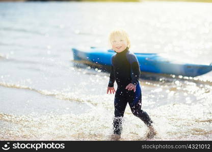Boy in water with canoe in background