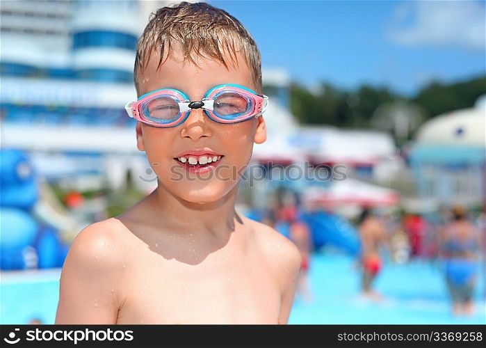 boy in watersport goggles near pool in aquapark of an entertaining complex